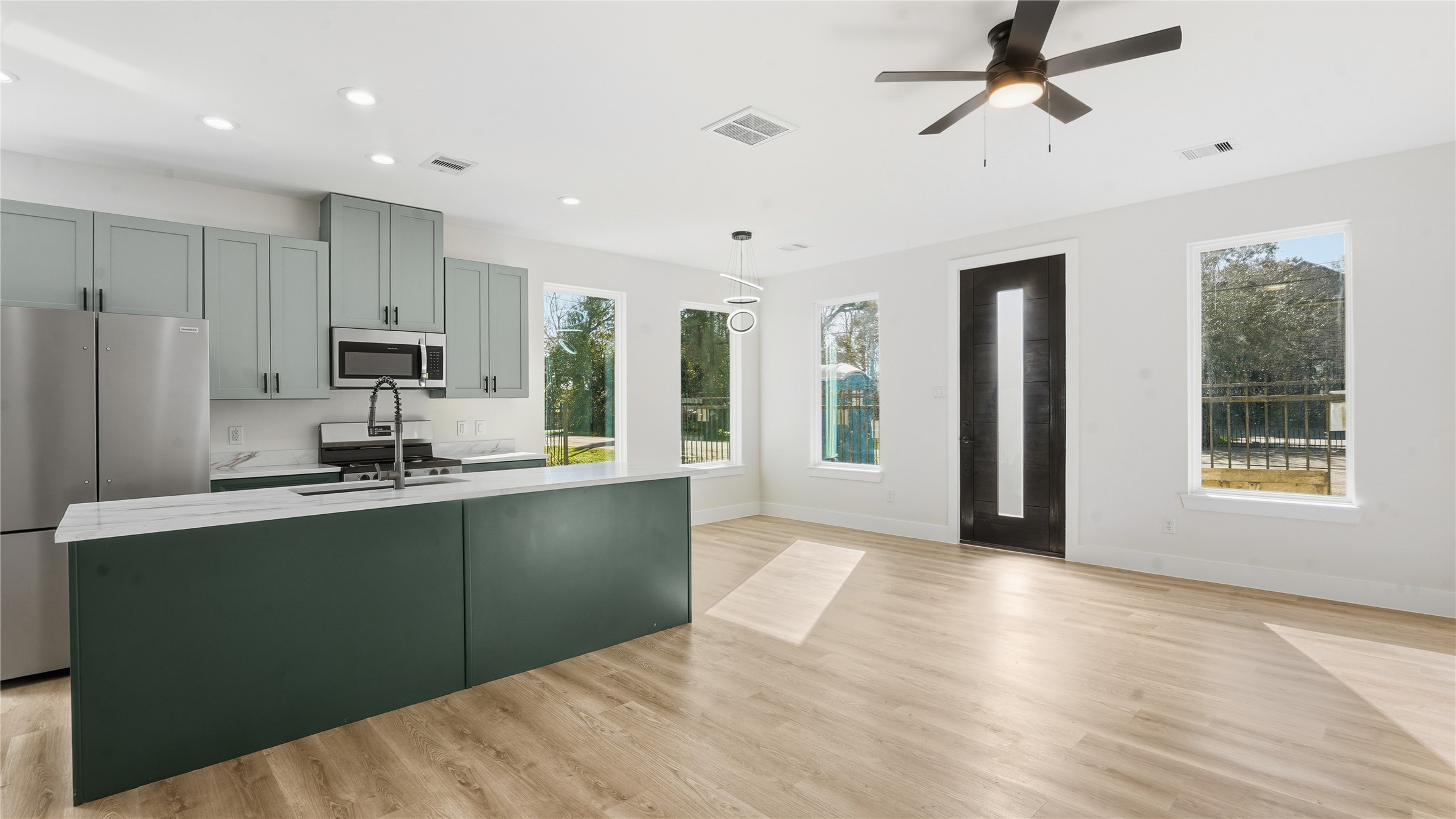 1317 Knight Street, Unit 1 Houston, TX 77022 - Photo 4 of 11 a kitchen with stainless steel appliances granite countertop a refrigerator a sink a stove a microwave and island