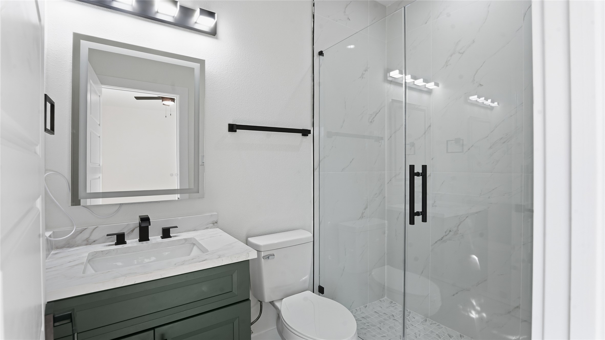 1317 Knight Street, Unit 1 Houston, TX 77022 - Photo 9 of 11 a bathroom with a granite countertop sink toilet a mirror and shower