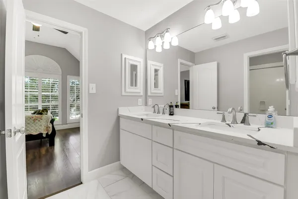 a en suite bathroom with a double vanity sink and a mirror