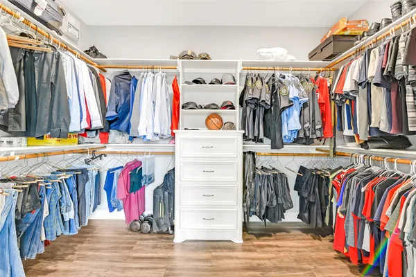 a view of walk in closet with clothes