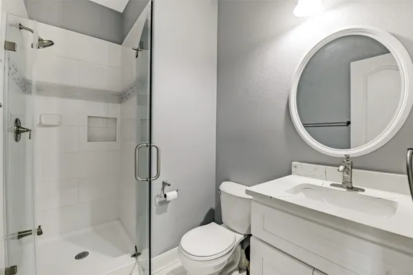 a bathroom with a sink a toilet and a mirror