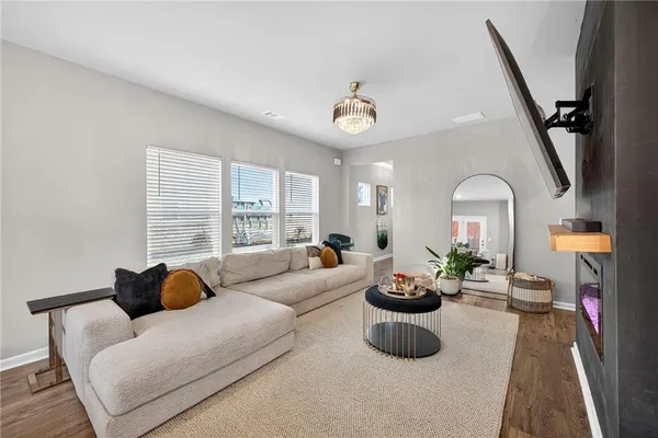 a living room with furniture potted plant and a large window