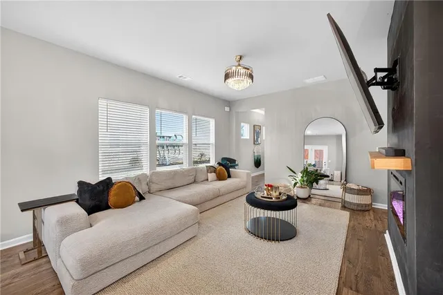 a living room with furniture potted plant and a large window