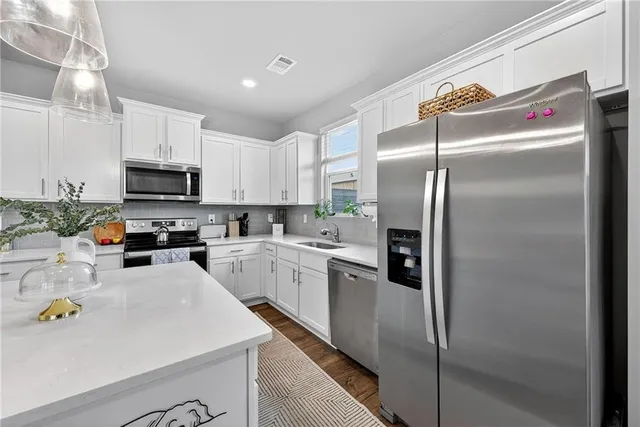 a kitchen with a refrigerator a microwave a sink and cabinets