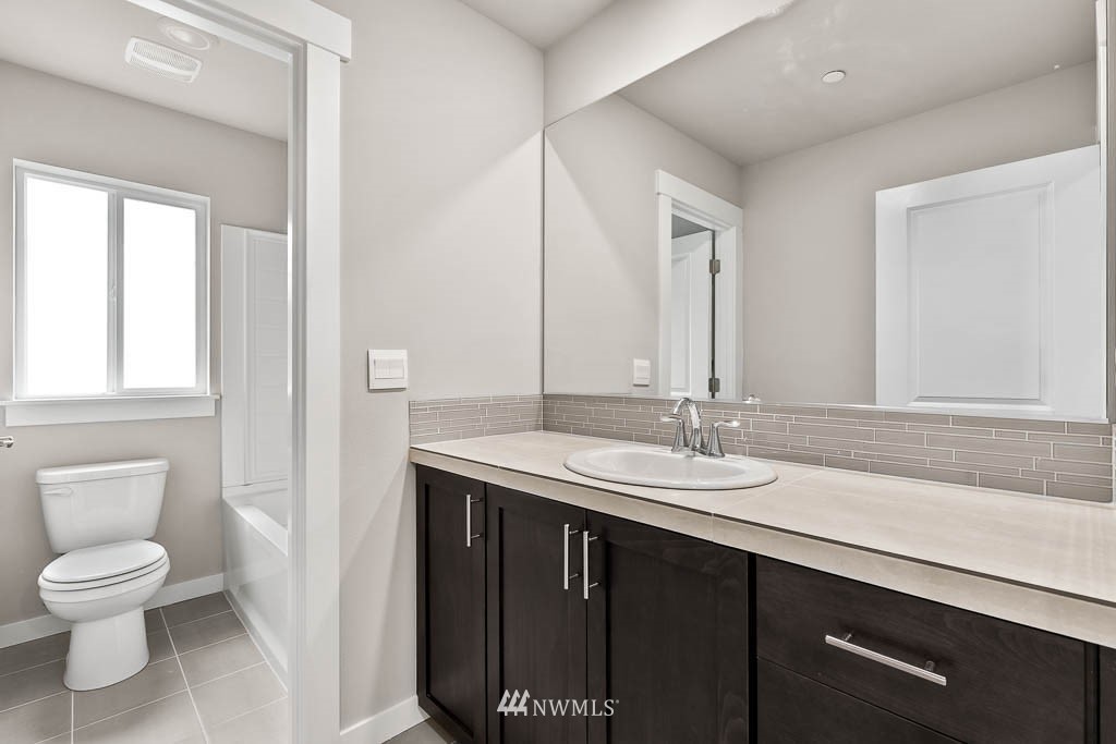 31 211th Street Southeast, Unit P15 Bothell, WA 98021 - Photo 14 of 40 a bathroom with a granite countertop sink a toilet and a mirror