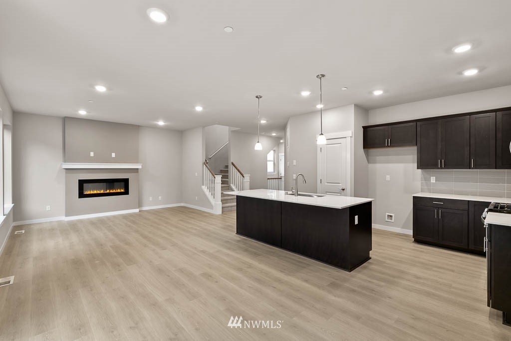 31 211th Street Southeast, Unit P15 Bothell, WA 98021 - Photo 3 of 40 a large kitchen with kitchen island granite countertop a stove top oven a sink a counter space and cabinets