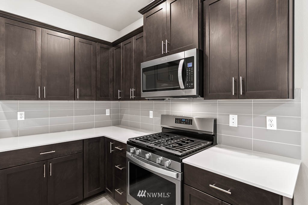 31 211th Street Southeast, Unit P15 Bothell, WA 98021 - Photo 30 of 40 a kitchen with granite countertop a stove and a microwave