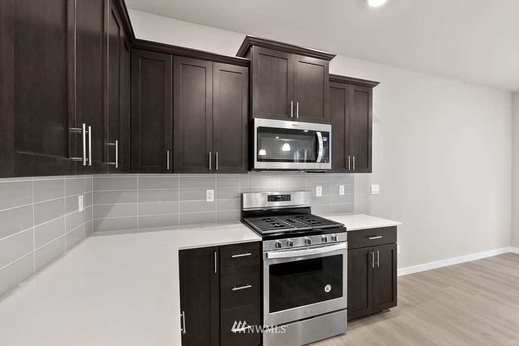 31 211th Street Southeast, Unit P15 Bothell, WA 98021 - Photo 5 of 40 a kitchen with granite countertop a stove and a microwave