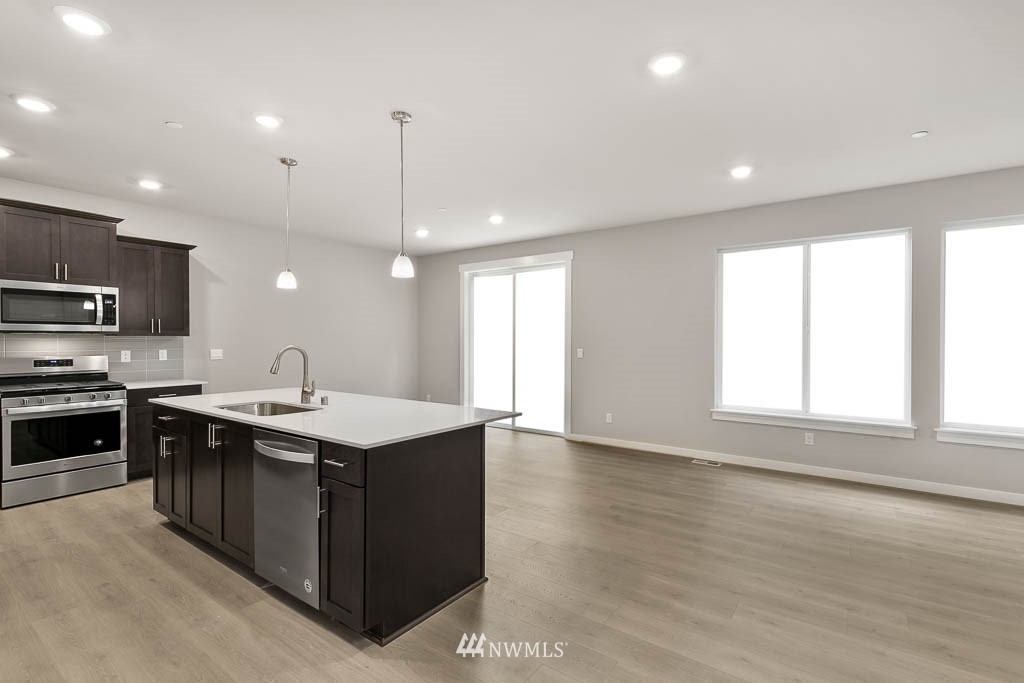 31 211th Street Southeast, Unit P15 Bothell, WA 98021 - Photo 6 of 40 a kitchen with stainless steel appliances granite countertop a sink a stove and a wooden floors