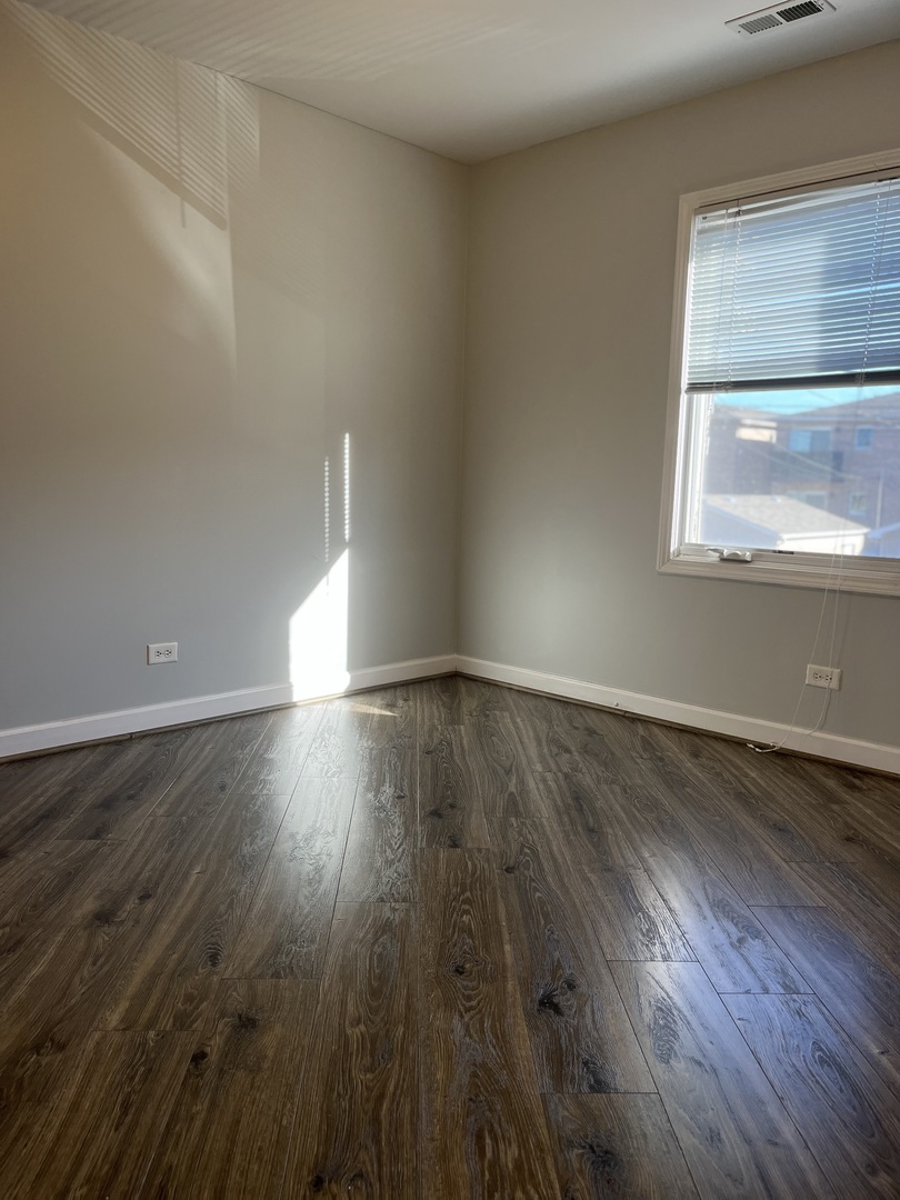 3431 Ridgeland Avenue, Unit 203 Berwyn, IL 60402 - Photo 11 of 18 an empty room with wooden floor and windows
