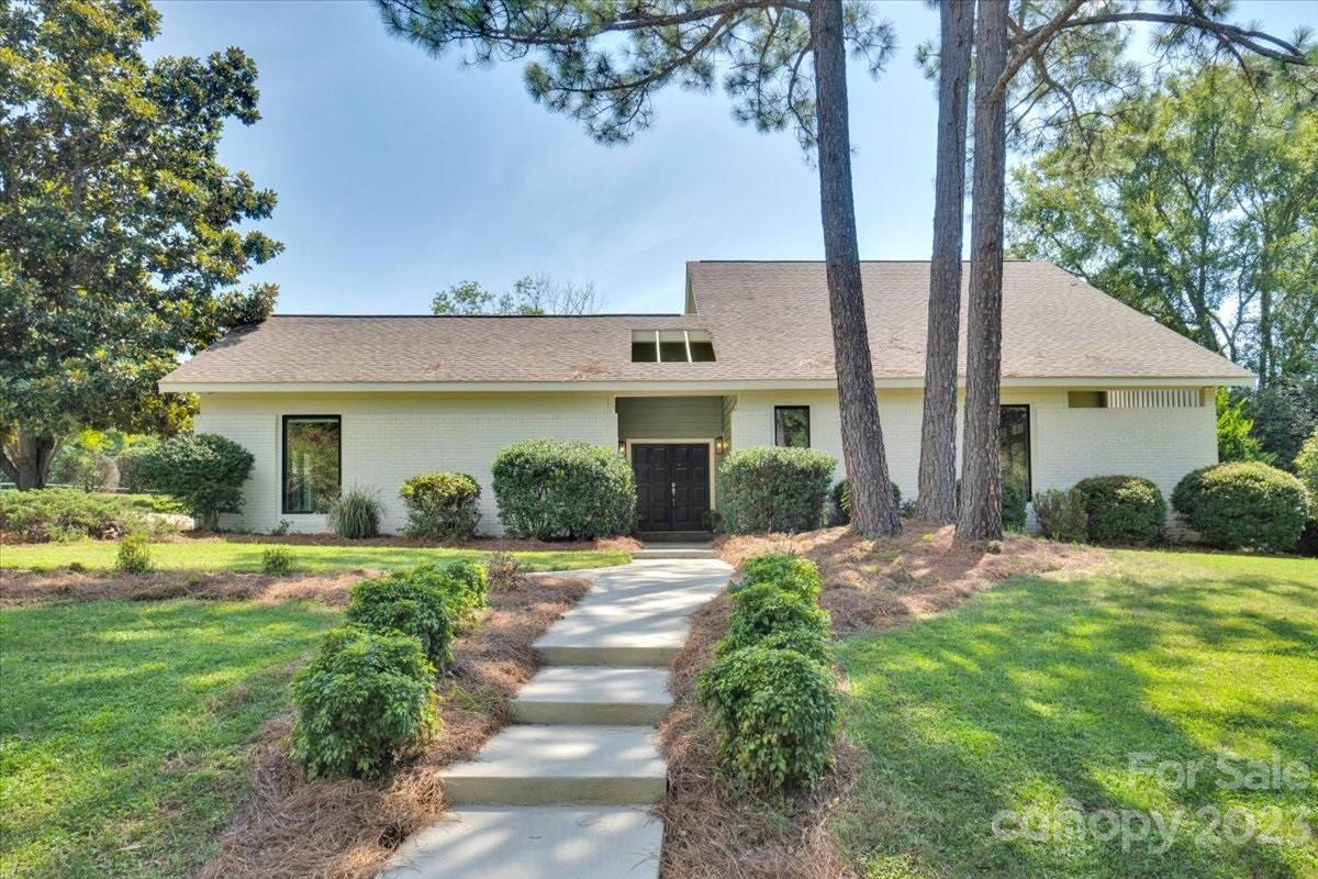 8301 Raintree Lane Charlotte, NC 28277 - Photo 1 of 42 a front view of a house with a yard and potted plants