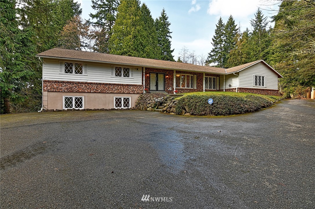5011 228th Street Southeast Bothell, WA 98021 - Photo 2 of 40 a front view of a house with a garden