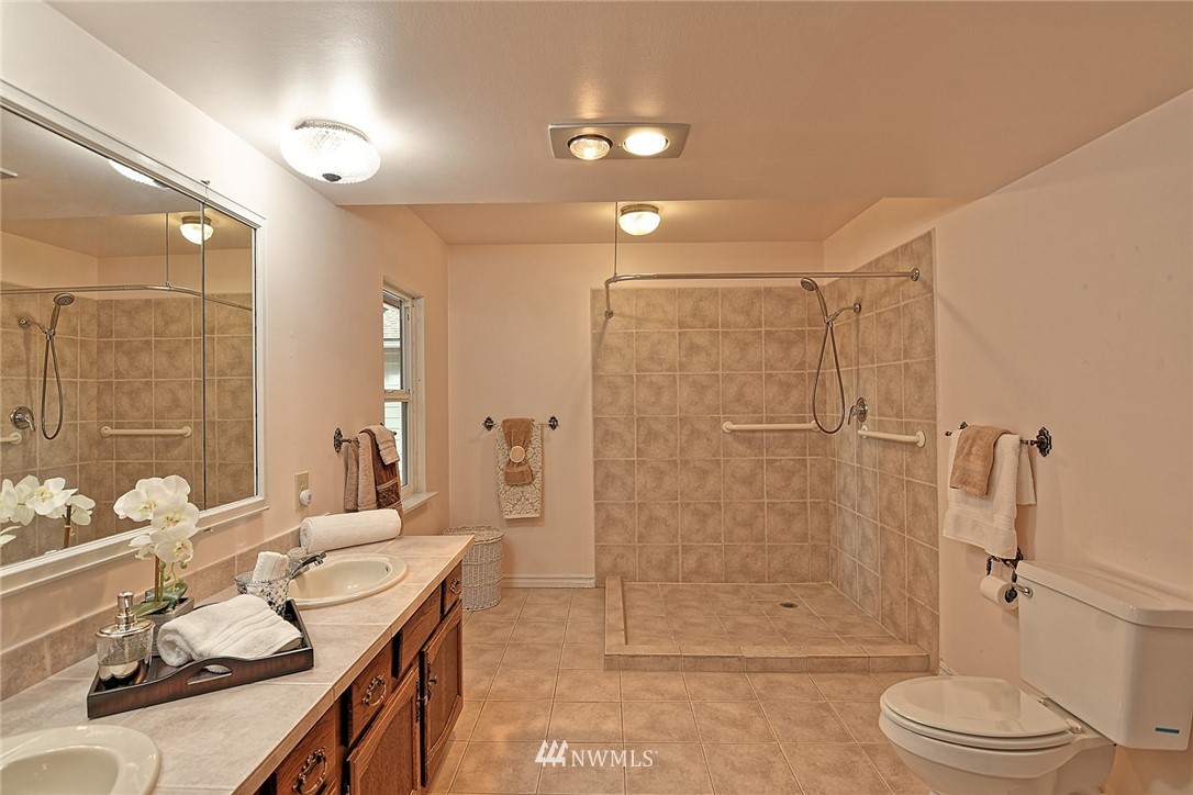 5011 228th Street Southeast Bothell, WA 98021 - Photo 13 of 40 a bathroom with a granite countertop sink a toilet and shower