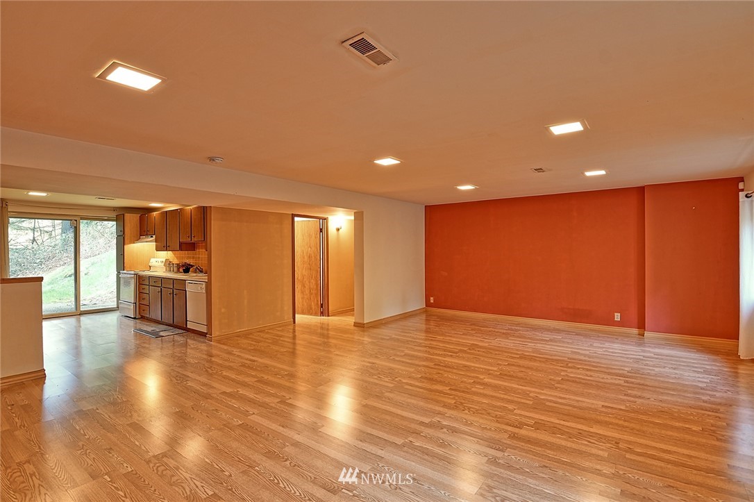 5011 228th Street Southeast Bothell, WA 98021 - Photo 25 of 40 a view of an empty room with wooden floor and windows