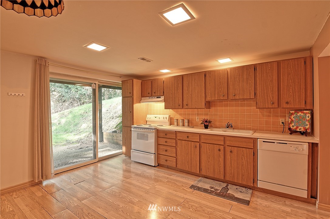 5011 228th Street Southeast Bothell, WA 98021 - Photo 26 of 40 a kitchen with sink cabinets and wooden floor