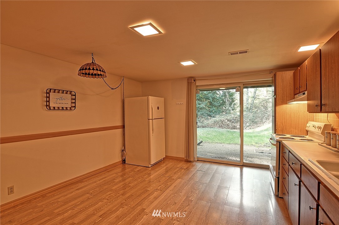 5011 228th Street Southeast Bothell, WA 98021 - Photo 27 of 40 a view of a kitchen with a fridge and wooden floor