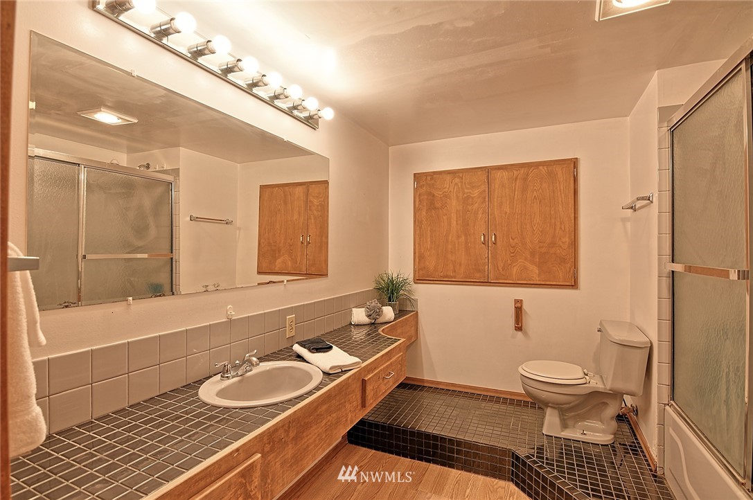 5011 228th Street Southeast Bothell, WA 98021 - Photo 29 of 40 a bathroom with a granite countertop double vanity sink a mirror and a bathtub