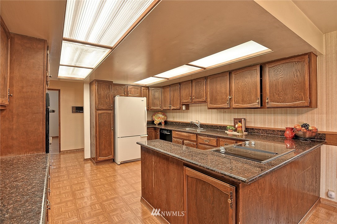 5011 228th Street Southeast Bothell, WA 98021 - Photo 9 of 40 a kitchen with stainless steel appliances granite countertop a sink a stove and a refrigerator
