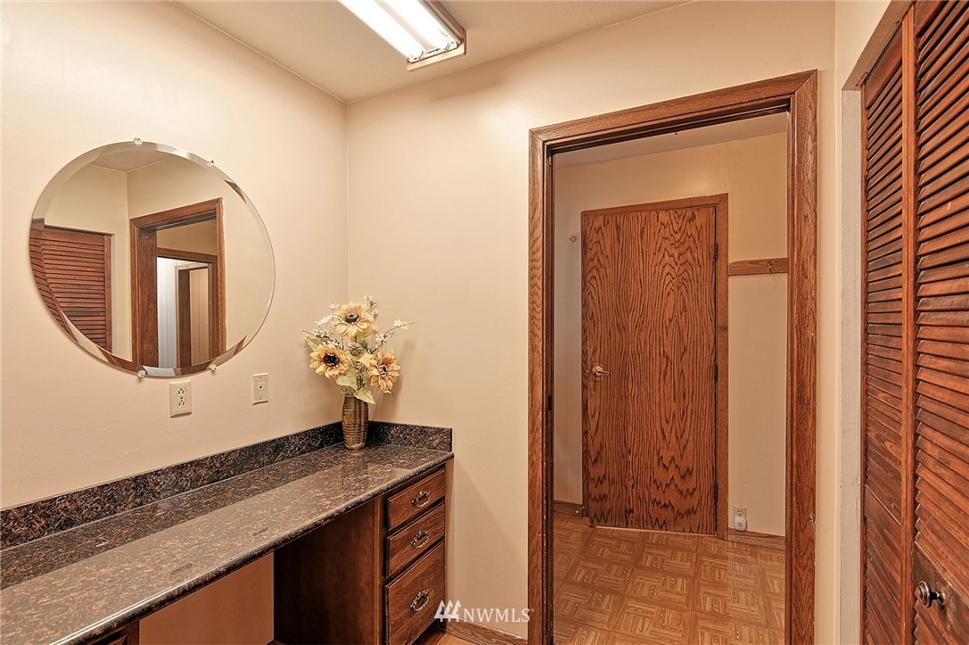 5011 228th Street Southeast Bothell, WA 98021 - Photo 10 of 40 a bathroom with a granite countertop sink a mirror and vanity