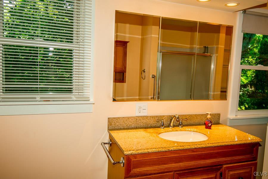 2121 7th Street Bethlehem, PA 18020 - Photo 8 of 14 a bathroom with a granite countertop sink and a large mirror