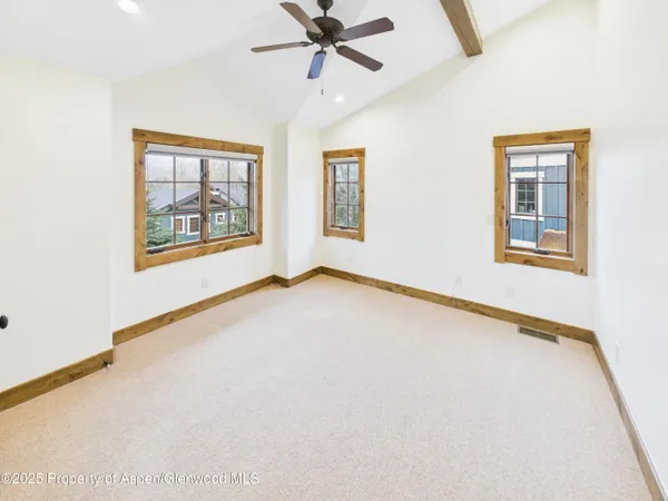 an empty room with windows and fan