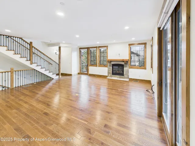 a view of a livingroom with fireplace wooden floor and windows