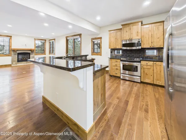 a view of a kitchen with a sink and a stove top oven with wooden floor