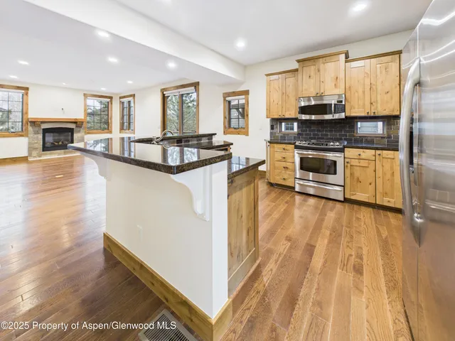 a view of a kitchen with a sink and a stove top oven with wooden floor