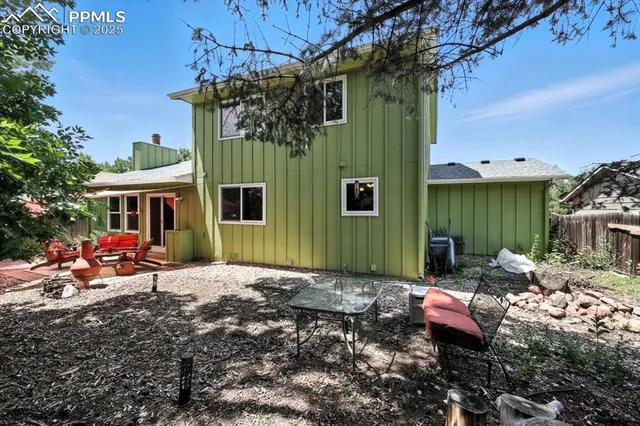 a view of a chair and table in backyard of the house