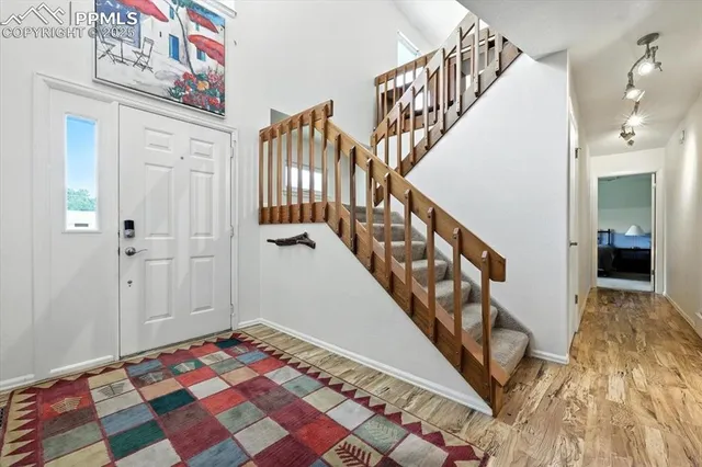 a view of a hallway with wooden floor and stairs