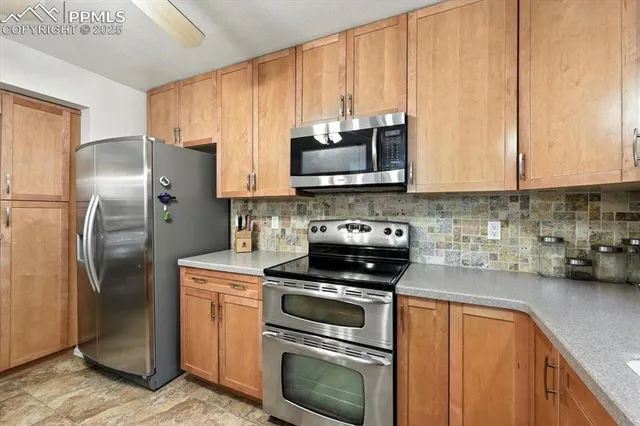 a kitchen with stainless steel appliances granite countertop a stove a refrigerator and a sink