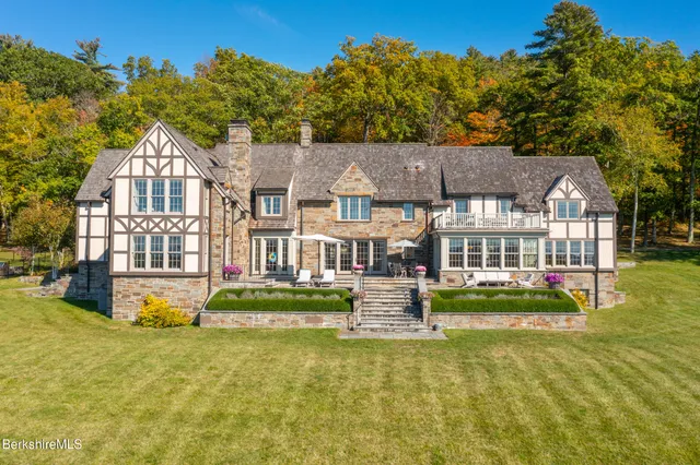 a living room with furniture kitchen view and large windows