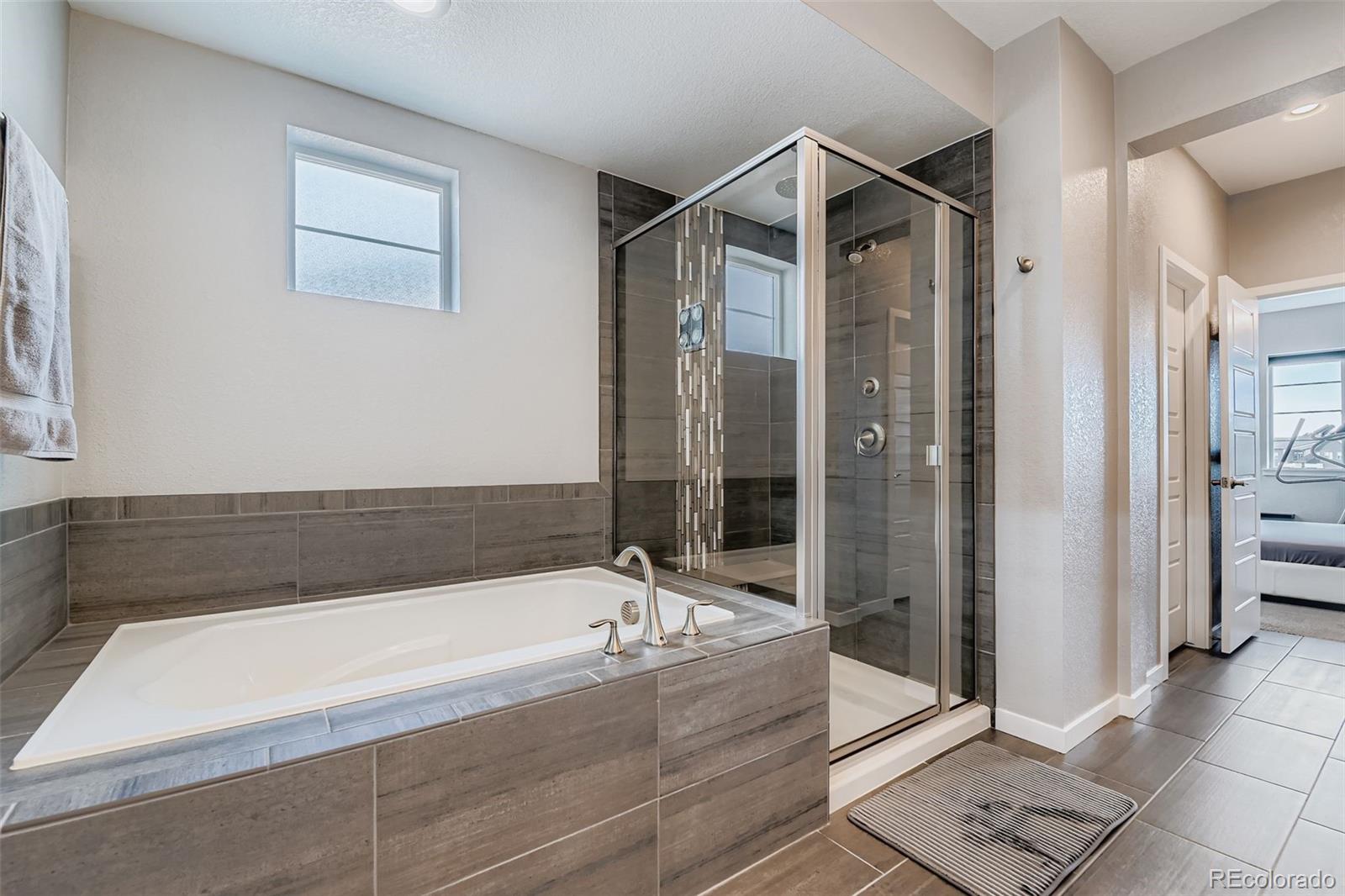 86 Nova Court Erie, CO 80516 - Photo 17 of 50 a bathroom with a bathtub and a shower