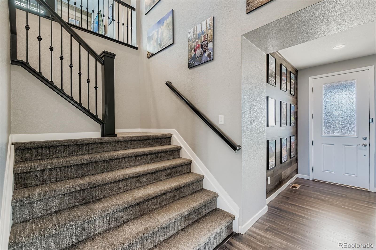86 Nova Court Erie, CO 80516 - Photo 3 of 50 a view of staircase with lots of frames on wall and wooden floor