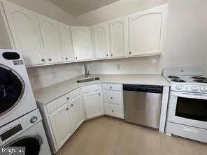 a kitchen with white cabinets and white appliances