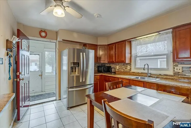 a kitchen with stainless steel appliances granite countertop a refrigerator a sink a stove and island