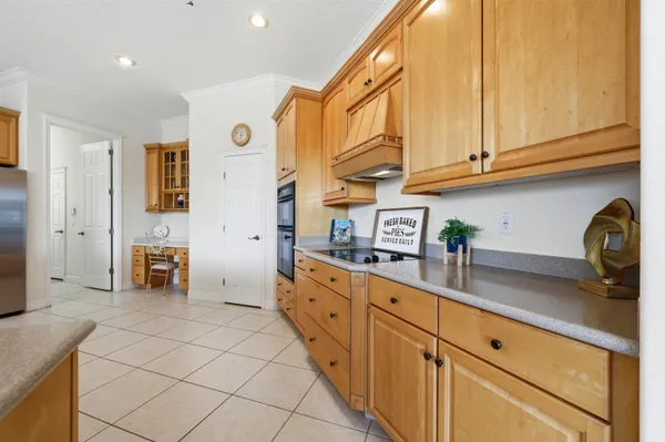 a kitchen with stainless steel appliances a sink a stove a refrigerator cabinets and a dining table