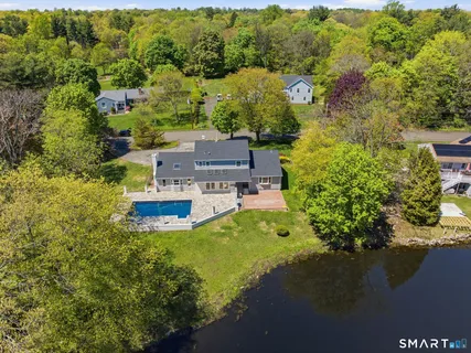 an aerial view of a house with a garden and lake view