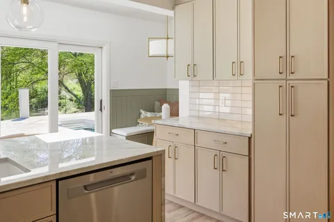 a kitchen with stainless steel appliances white cabinets and a window