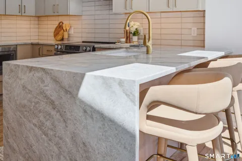 a kitchen with a sink and a stove with wooden floor