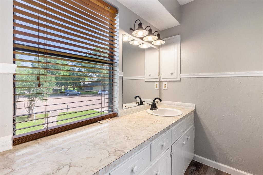 2820 Bois D'Arc Street Commerce, TX 75428 - Photo 29 of 40 a bathroom with a sink and a mirror
