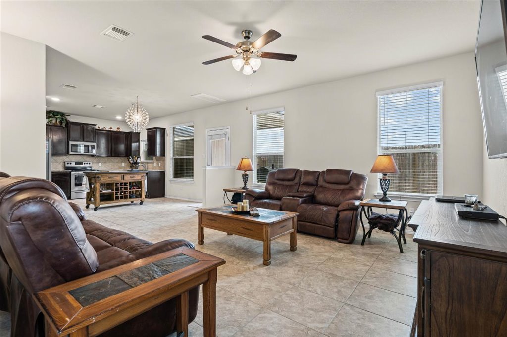 212 Plata Lane Jarrell, TX 76537 - Photo 7 of 30 Living room featuring ceiling fan, light tile patterned floors, and suspended lighting