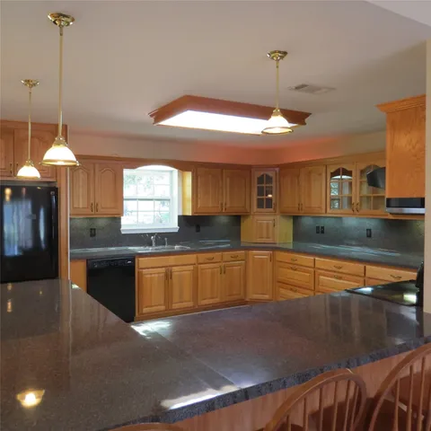 a kitchen with stainless steel appliances granite countertop a stove a sink and a wooden floors