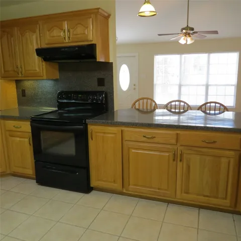 a kitchen with granite countertop a sink and a stove