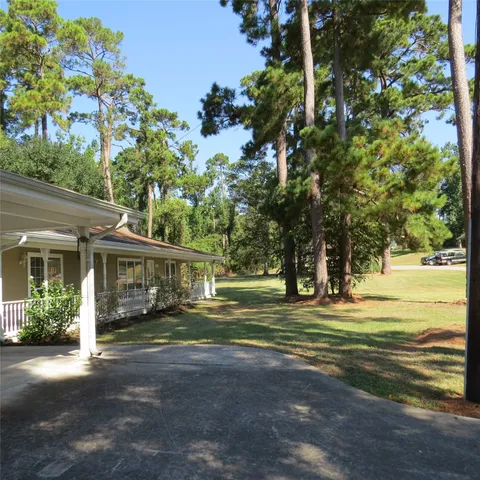 a front view of a house with a yard and trees