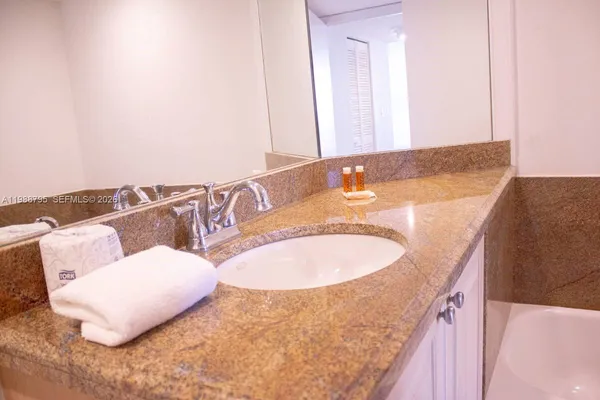 a bathroom with a granite countertop sink and a mirror
