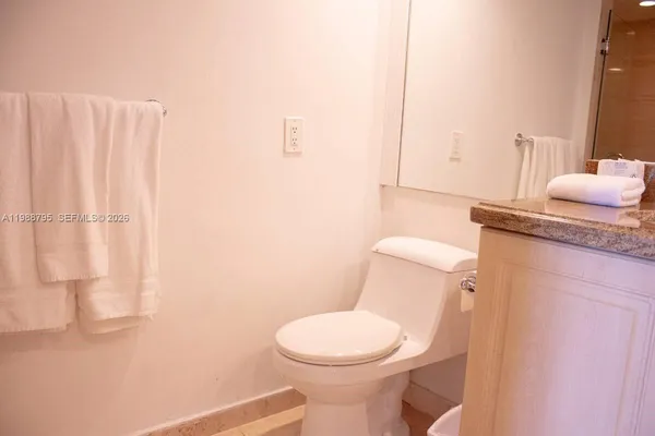 a white toilet sitting next to a bathroom sink