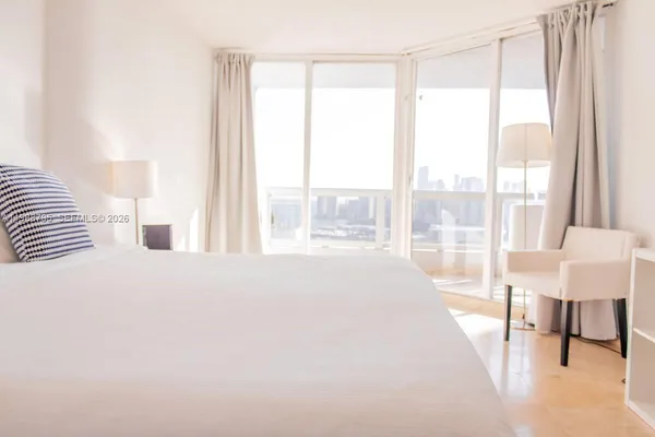 a large bedroom with a bed and a large window