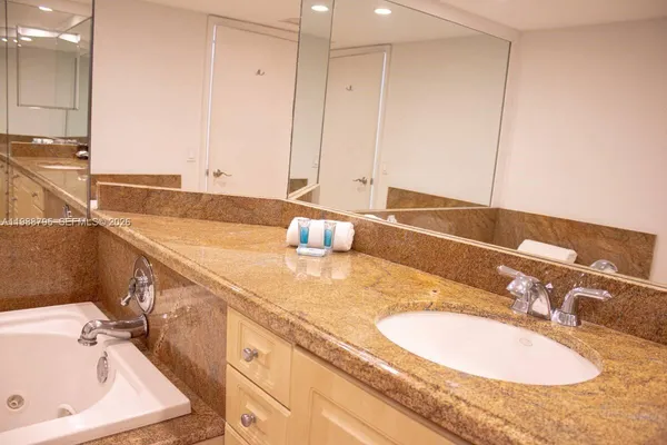 a bathroom with a granite countertop sink and a mirror
