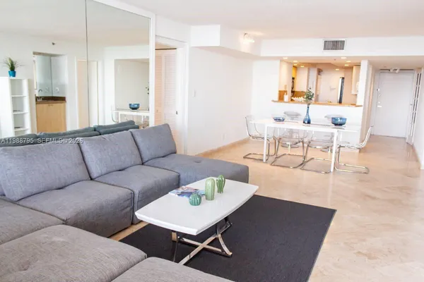 a living room with furniture a wooden floor and a chandelier